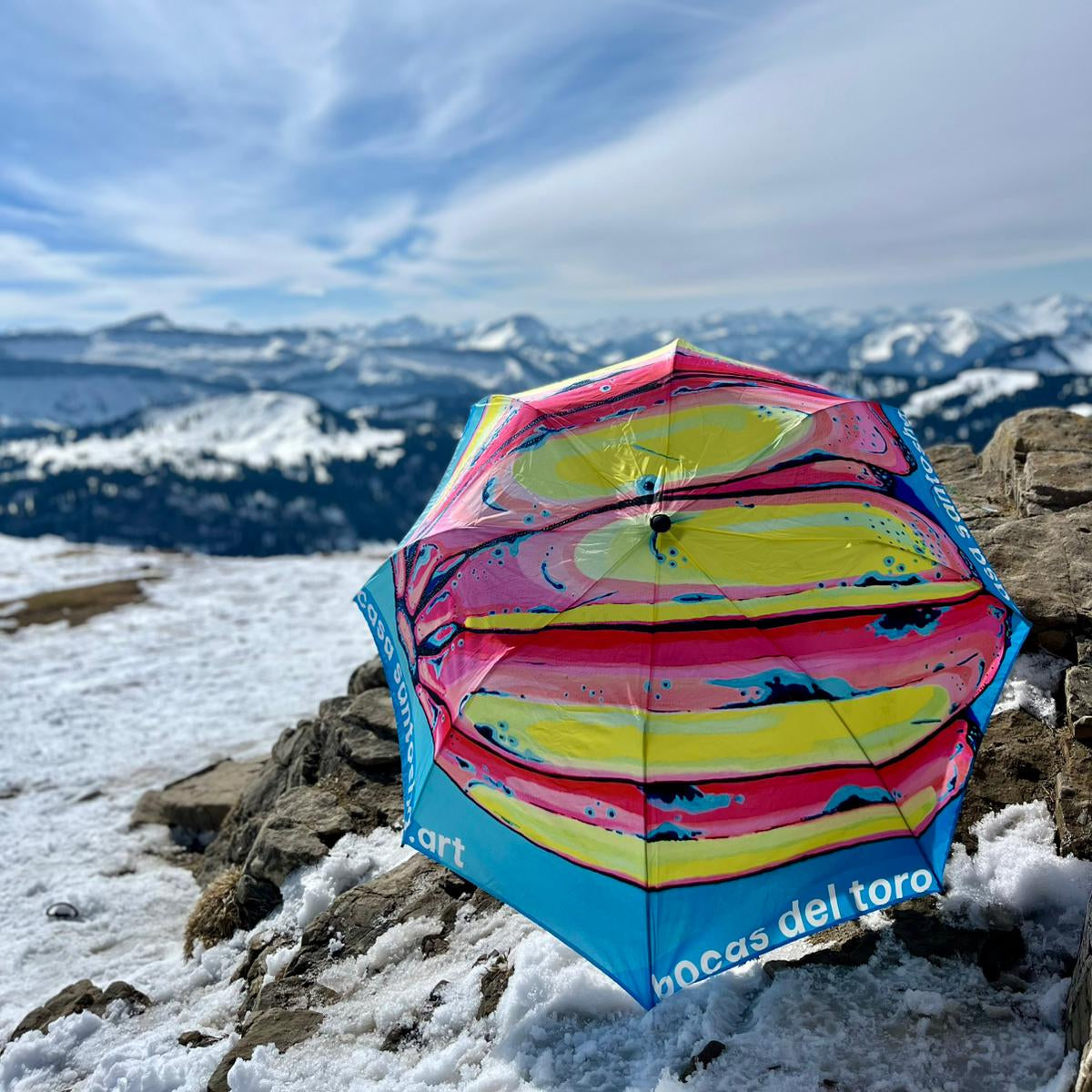 Colorful umbrella with abstract design on a snowy mountain landscape