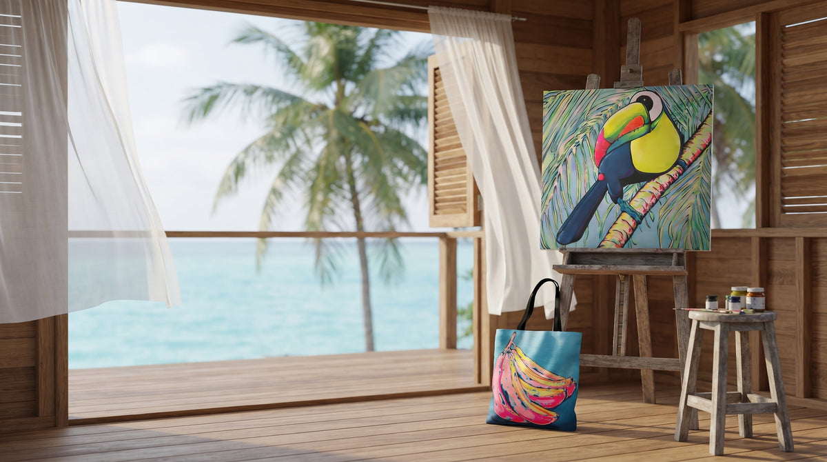 Neon pop art painting of a Toucan on an easel and a matching neon bananas bag in a breezy Caribbean art studio overlooking turquoise water and palm trees in Bocas del Toro, Panama
